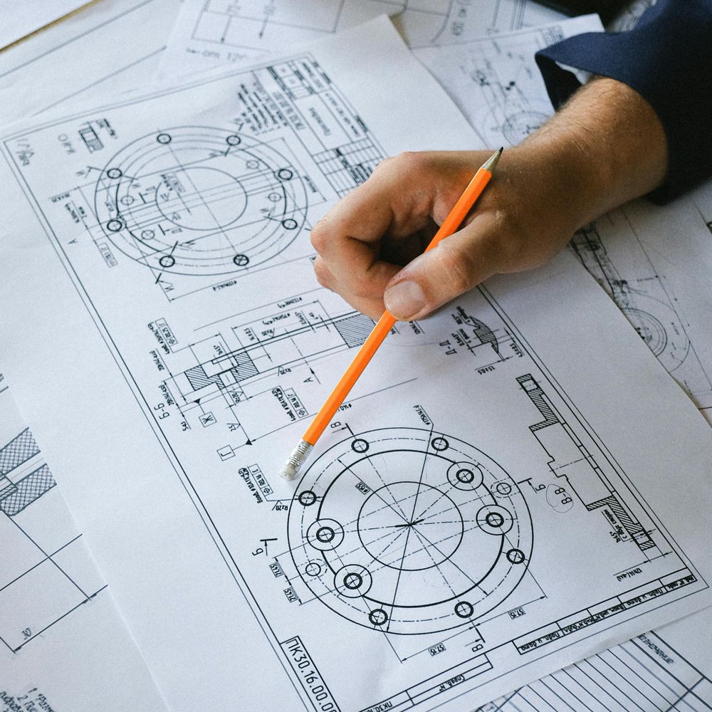technikai megbeszélés asztalra kiterített rajzok segítségével